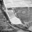 Oblique aerial view centred on the site of the enclosed cremation cemetery with the cropmarks of the enclosure adjacent, taken from the ENE.