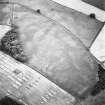 Raith, oblique aerial view taken from the NE, centred on the site of a Roman Signal Station and the cropmarks of a series of pits.  In the top left hand corner of the photograph the cropmark of a possible sunken floored building is visible.