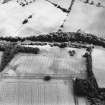 Oblique aerial view of Innerpeffray centred on the remains of the tower house and the cropmarks of a possible garden, a fort, and a pit-alignment, taken from the NNW.