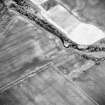 Oblique aerial view centred on the cropmarks of the enclosure with possible enclosure and enclosed cremation cemetery adjacent, taken from the ESE.