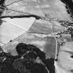 Logierait, oblique aerial view taken from the NW, centred on the cropmarks of a souterrain, roundhouses, pits and a fort.  A possible enclosure is also visible in the top left hand corner.  There are also numerous linear cropmarks showing in the photograph.