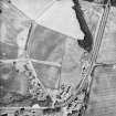 Logierait, oblique aerial view taken from the SW, centred on the cropmarks of a souterrain, roundhouses, pits and a fort.  A possible enclosure is also visible in the top right hand corner of the photograph.  There are also numerous linear cropmarks showing in the photograph.