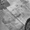 Oblique aerial view centred on the cropmarks of the possible long cist cemetery and pits with the remains of the standing stone adjacent, taken from the ESE.