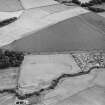Oblique aerial view of Dunning centred on the cropmarks of a Roman temporary camp, taken from the NW.