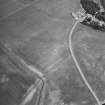 Oblique aerial view centred on the cropmarks of the pits, rig and enclosure with house adjacent, taken from the S.