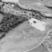 Oblique aerial view of Dun Knock centred on the cropmarks of the fort and plantation bank, taken from the NNE.
