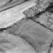 Oblique aerial view of Luncarty centred on the cropmarks of a settlement, enclosure, and cultivation remains, also visible are linear cropmarks, taken from the ESE.