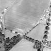 Oblique aerial view centred on the cropmarks of the unenclosed settlement with church and smithy adjacent, taken from the SW.
