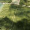 Oblique aerial view centred on the faint cropmarks of an enclosure with linear cropmarks adjacent, taken from the SSE.