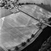Oblique aerial view of Victoria Cottage centred on linear cropmarks with farmhouse, farmsteading, road bridge and village adjacent, taken from the SW.