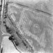 Oblique aerial view of Newmill Cottages centred on the cropmarks of a palisaded enclosure, souterrain, round house, pit-alignment and other cropmarks, taken from the SSE.