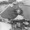 Oblique aerial view centred on the cropmarks of the fort, taken from the NW.