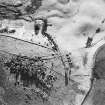 Oblique aerial view centred on the remains of the farmsteads, taken from the NNE.