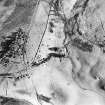 Oblique aerial view centred on the remains of the farmsteads, taken from the WNW.