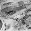 Oblique aerial view centred on the remains of the farmsteads, taken from the SW.