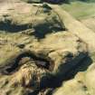 Oblique aerial view centred on the remains of hut-circles with rig and enclosures adjacent, taken from the ENE.