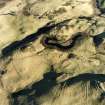 Oblique aerial view centred on the remains of hut-circles with rig and enclosures adjacent, taken from the WSW.