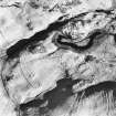 Oblique aerial view centred on the remains of hut-circles with rig and enclosures adjacent, taken from the WNW.