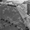 Ballathie, oblique aerial view, taken from the SE, showing the cropmarks of a group of pits in the centre of the photograph, and an unenclosed settlement in the bottom left-hand corner.  A dismantled railway is visible as a cropmark along the bottom half.