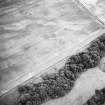 Hallhole, oblique aerial view, taken from the NE, centred on the cropmarks of a round house within an enclosure. Cropmarks including those of pits and rig are scattered across the same field.