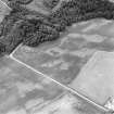 Oblique aerial view centred on the cropmarks of an unenclosed settlement with natural feature adjacent, taken from the SE.