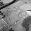 Oblique aerial view centred on the cropmarks of the enclosure and pits with the farmhouse and farmsteading adjacent, taken from the SW.