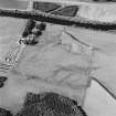 Oblique aerial view centred on the cropmarks of the enclosure and pits with the farmhouse and farmsteading adjacent, taken from the SE.