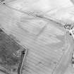 Oblique aerial view centred on the cropmarks of the possible buildings or mortuary enclosures and rig with the pit-alignment and the farmhouse and farmsteading adjacent, taken from the ESE.