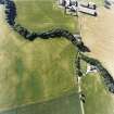 Oblique aerial view centred on the cropmarks of the fort, unenclosed settlement, souterrains and barrows, taken from the SE.