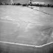 Oblique aerial view centred on the cropmarks of the ring-ditches and rig, taken from the NE.