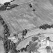 Oblique aerial view centred on the cropmarks of rig and possible timber halls with rectiliear enclosure, field boundaries, ice house, farmsteading, house and country house adjacent, taken from the SSE.