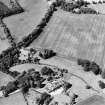 Oblique aerial view centred on the cropmarks of rig and possible timber halls with rectiliear enclosure, field boundaries, ice house, farmsteading, house and country house adjacent, taken from the ESE.