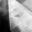 Oblique aerial view centred on the cropmarks of the unenclosed settlement and souterrains, taken from the NNW.