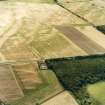 Oblique aerial view centred on the cropmarks of the pit-defined enclosure with the cropmarks of the barrow and pits, adjacent, taken from the NNE.