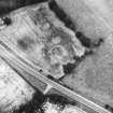Oblique aerial view centred on the cropmarks of an enclosure and unenclosed settlement.