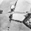 Oblique aerial view centred on the cropmarks of an enclosure and unenclosed settlement.