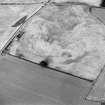 Oblique aerial view centred on the cropmarks of an enclosure with possible unenclosed settlement adjacent, taken from the WSW.