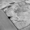 Oblique aerial view centred on the cropmarks of an enclosure with possible unenclosed settlement adjacent, taken from the SSW.