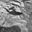 Oblique aerial view centred on the remains of a farmstead with farmsteads, farmsteading, possible hut circle, buildings and banks adjacent, taken from the NNW.