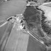 Oblique aerial photograph of Milton, Leuchars and Black Wood centred on cropmarks, taken from the NW. The cropmarks of cultivation remains, a possible souterrain and a sunken floored house are situated to the W. A cropmark complex is situated to the NE, in the bottom left corner of the photograph.