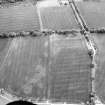 Oblique aerial view centred on the cropmarks of pits, a roundhouse, possible enclosure and rig, taken from the E.