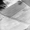 Oblique aerial view centred on the cropmarks of the pit-defined cursus with enclosure and possible barrow adjacent, taken from the SW.