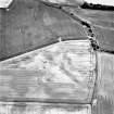 Ironshill, oblique aerial view, taken from the NW, centred on the cropmarks of an enclosure, pits and linear cropmarks. A field boundary is visible in the top left-hand corner of the photograph.