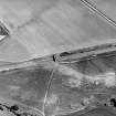 Oblique aerial view centred on the cropmarks of the ring-ditch, taken from the WNW.