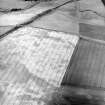 Oblique aerial view centred on the cropmarks of the unenclosed settlements, pit-alignment, pits and rig, taken from the SE.