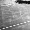 Newbigging, oblique aerial view, taken from the SSE, centred on the cropmarks of an enclosure, a ring-ditch, pits and a barrow.