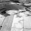 Oblique aerial view centred on the cropmarks of the cursus, enclosure, rig, barrows, and ring-ditch, taken from the SE.