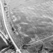 Oblique aerial view of Purlieknowe centred on the cropmarks of a pit-defined cursus with linear cropmarks and a possible pit-alignment adjacent, taken from the ENE.