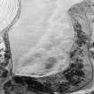 Oblique aerial view of Kinghornie centred on the cropmarks of possible graves with round-houses, a possible souterrain, pits and a possible enclosure adjacent.  In addition, there are the remains of a pillbox and anti-tank blocks on the shore. Taken from the WSW.