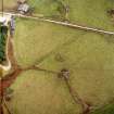 Oblique aerial view centred on the remains of the stone circle, ring cairn and field system, taken from the WNW.